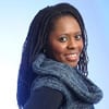 Bianca Forbes headshot photo, smiling woman wearing dark top in front of light background