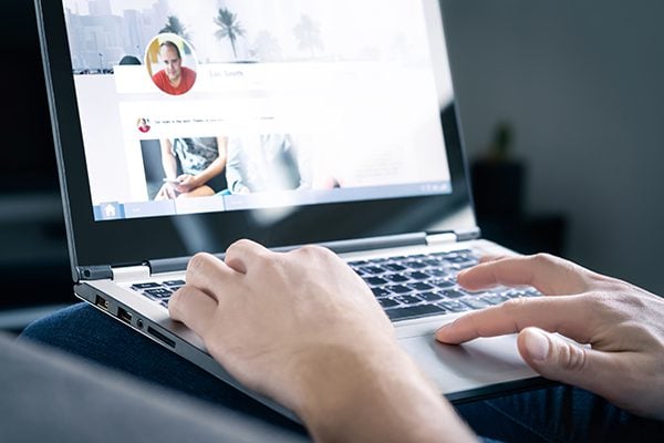 coach updating their social media profile on a laptop