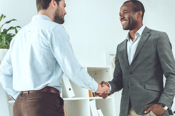 person meeting their coach for the first time and shaking hands