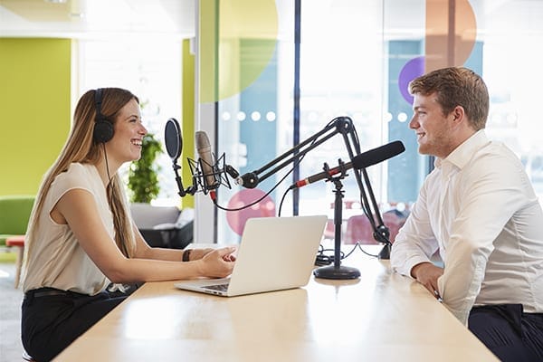 two people at a table recording a podcast
